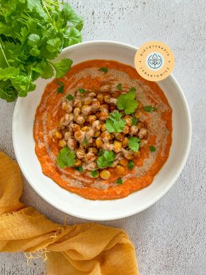 Pomysł na zdrowy odżywczy obiad wegetariański z ciecierzycą, pomidorami, mlekiem kokosowym i masłem migdałowym.