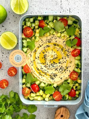 Obiad wege w pudełku do zabrania do pracy, z hummusem, cukinią, pomidorkami, kolendrą, pełen antyoksydantów i polifenoli oraz zdrowych tłuszczy.