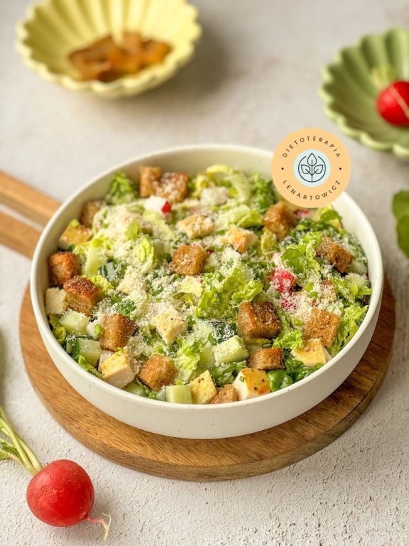 Sałatka na kolację z grzankami, kurczakiem, rzodkiewką, parmezanem, sałatą rzymską. Zdrowy posiłek bogaty w l-tryptofan będący kofaktorem w produkcji serotoniny.