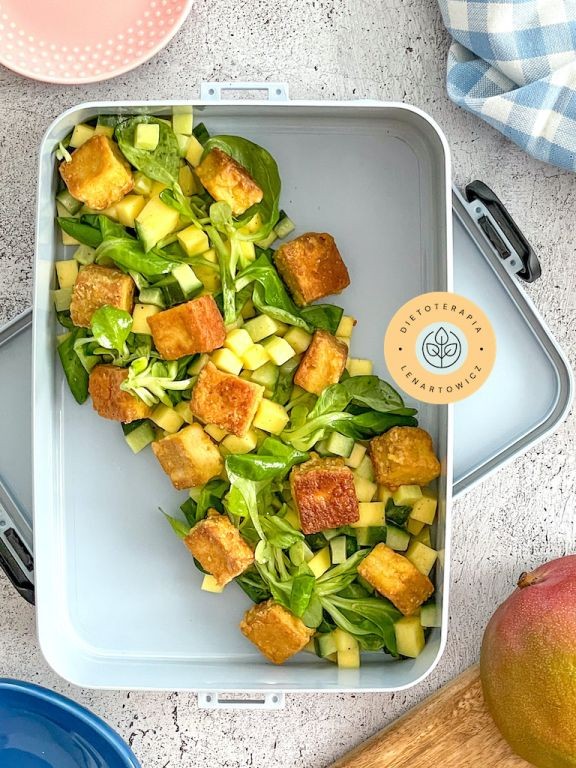 Sałatka w stylu orientalnym z tofu, mango, cieciorką, imbirem, jajkami, oliwkami do zapakowania do pudełka na wynos.