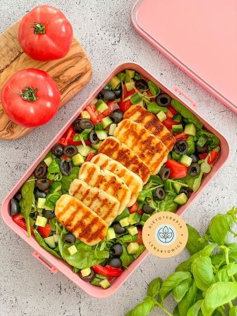 Halloumi na sałatce z roszponki, szpinaku, oliwek, zapakowane w pudełku do pracy lub szkoły.