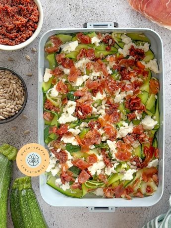 Pomysł na zdrową szybką kolację z cukinią pokrojoną w tagliatelle, fetą, szynka parmeńską, pomidorami suszonymi.