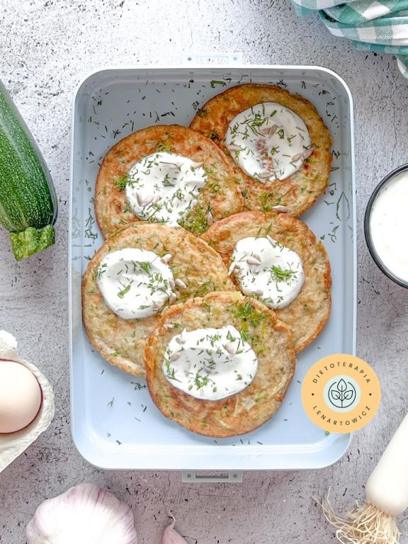 Placki z cukinii i pora, z dodatkiem styru z koperkiem, zapakowane do pudeÅka na wynos. Zdrowe Åniadanie do zabrania do pracy.